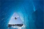 COMPOSITE : Vue depuis l'intérieur d'une grotte de glace d'iceberg congelé comme un grimpeur de glace du lac Mendenhall rappels descendre une corde, Juneau, sud-est de l'Alaska, hiver