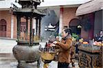 Un adorateur offrant au temple bouddhiste, Shantou, Chine