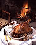 Capon with chestnuts, on table with fireplace