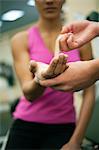 Person wrapping bandage around woman's hand, cropped