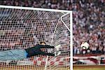 Soccer goalkeeper diving to guard net