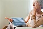 Senior Woman sitting auf Sofa mit Buch