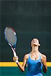 Young female tennis player cheering, portrait