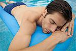 Young man lying on stomach on inflatable float