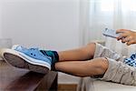 Boy sitting on couch with remote control