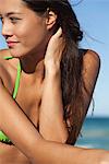 Young woman in bikini sunbathing, cropped