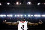 Basketball player with arms outstretched, rear view