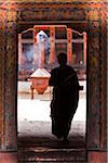 Monk with incense sticks at the beautiful 7th century Jampey Lhakhang, near Jakar in the Chokhor Valley.