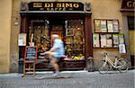 Italy, Tuscany, Lucca. A person cycling in front of one of the most famous bars in town