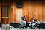 Japan, Chubu Region, Kyoto, Gion. A bicycle rests against the wall of a traditional building.