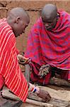 Maasai men play mancala at a manyatta in the Masai Mara, Kenya.