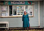 Sakhalin, Yuzhno-Sakhalinsk, Russia; A woman choosing products to buy at a 'moloko' kiosk - found all over Russia, these are normally small kiosks selling milk products