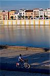 Espagne, Andalousie, Séville. Homme cyclisme sur la rive du fleuve Guadalquivir