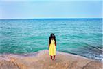 Thailand, Ko Samui, Chaweng beach, Girl standing on rock looking out to sea