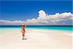 Tanzania, Zanzibar, Unguja, Niamembe Island. A woman walks towards the sea. MR.