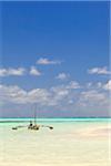 Tanzania, Zanzibar, Unguja, Jambiani. A man sits on his boat.