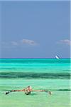 Tanzania, Zanzibar, Unguja, Jambiani. A traditional dhow moored near the shore.