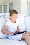 Girl using tablet computer on sofa