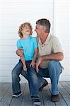 Smiling father and son on deck