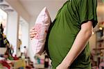 Pregnant woman holding pillow to belly