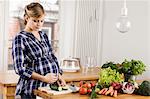 Pregnant woman chopping vegetables