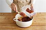 Woman spooning meat into tupperware