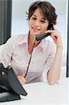 Businesswoman talking on phone at desk