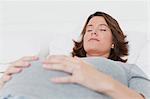 Sleeping woman holding pregnant belly