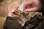 Man pulling fishing tackle from box