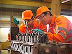 Engineer teaching apprentice in factory