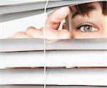 Woman peeking through blinds