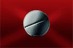 Close up of pill on red surface