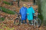 Portrait de couple d'âge mûr sur le vélo dans la forêt