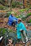 Mature couple in forest with bicycles