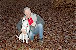 Portrait of senior man with dog in forest