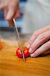 Mid adult woman slicing cherry tomatoes