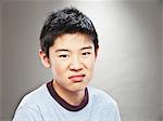 Portrait of grimacing young Asian teenage boy