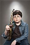 Portrait of young teenage boy holding saxophone