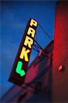 Illuminated neon parking sign on building