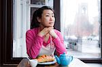 Female cafe owner thinking over breakfast