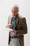 Mature man looking at digital tablet, studio shot