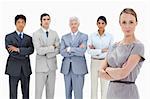 Close-up of a multicultural business team with their arms folded focus on a woman in foreground against white background