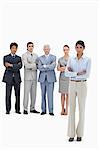 Serious multicultural business team with their arms folded with a woman in foreground against white background