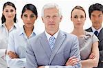 Close-up of a serious multicultural business team behind their boss against white background