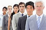 Close-up of business people in a single line with focus on the fourth person against white background