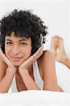 Close-up of a frizzy haired woman listening to music with headphone