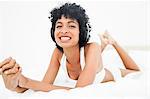 Frizzy haired woman smiling from ear to ear while listening music