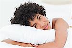 Portrait of a beautiful woman hugging her pillow against white background