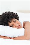 Portrait of a cute woman hugging her pillow against white background