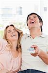 A close up shot of a man and woman laughing together at a television programme.